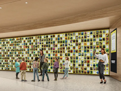 People walking inside the National Geographic Museum of Exploration with a colorful wall in the background.